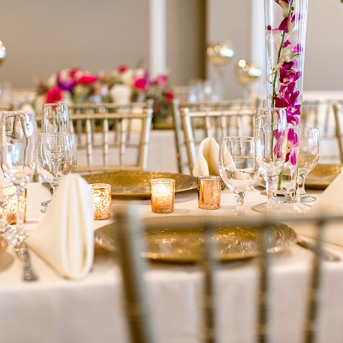 A beautifully set table with elegant tableware, folded napkins, candlestick holders, and floral arrangements for a formal event or celebration.